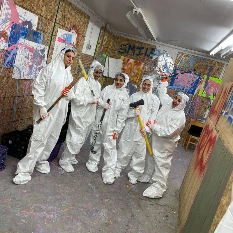 women in matching white rage room equipment posing for a photo at unity rage room